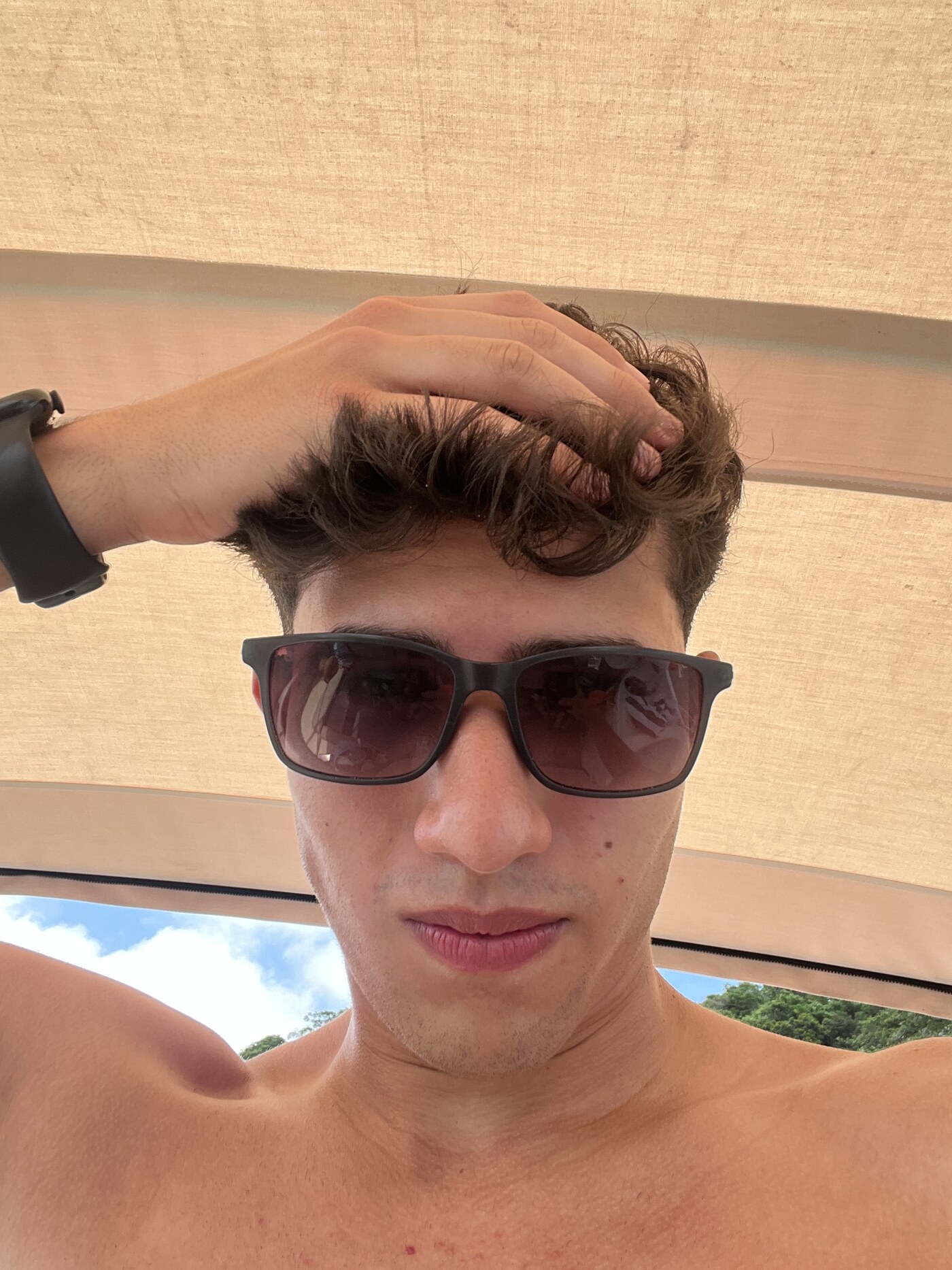 Matheus Barros de óculos escuros em um dia de verão no litoral