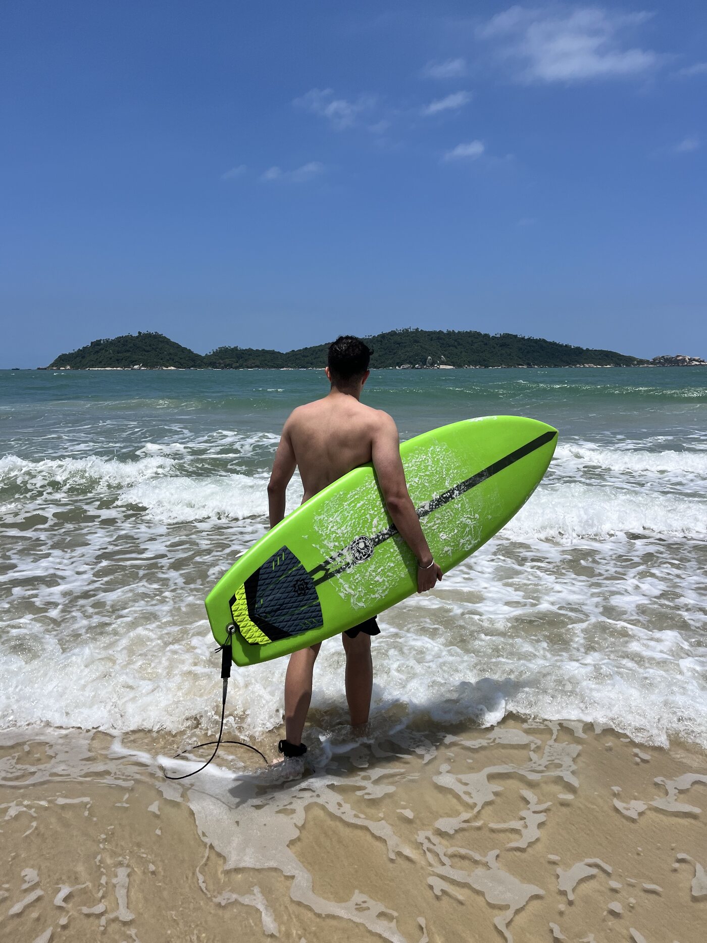 Matheus Barros entrando no mar com uma prancha de surf